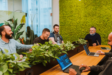 People in a office with plants having a meeting